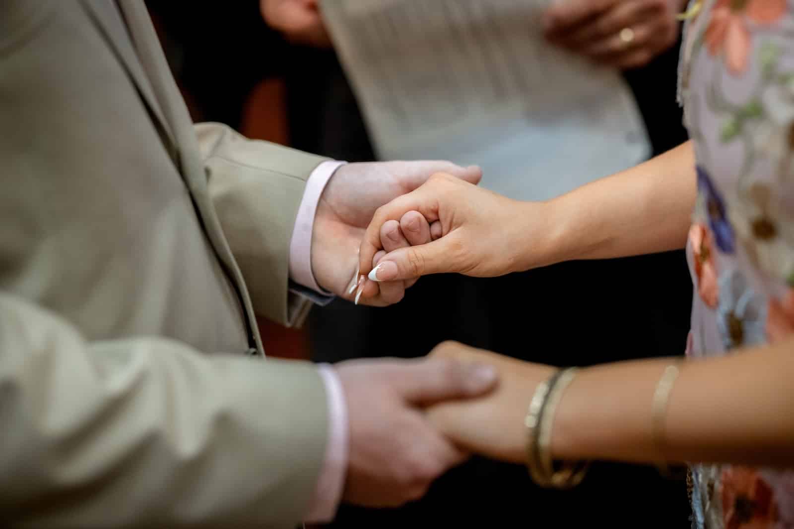 Couple Holding Hands Before Judge at Wedding Ceremony on their Alaska Elopement 